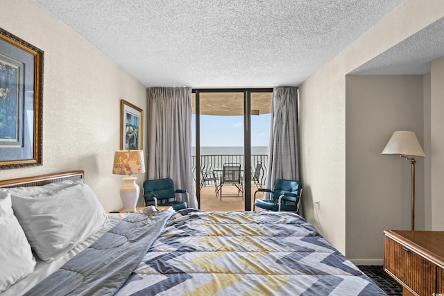 2500 N Ocean Blvd Unit 601, Myrtle Beach, SC 29577 - bedroom featuring access to outside, a textured ceiling, a wall of windows, a textured wall, and a water view