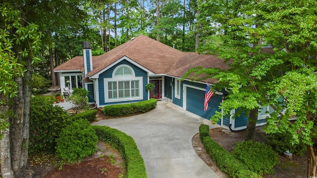 1325 Clipper Dr, North Myrtle Beach, SC 29582 - view of front facade with concrete driveway, a garage, a chimney, and roof with shingles