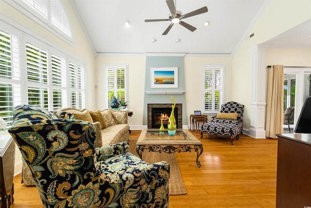 1325 Clipper Dr, North Myrtle Beach, SC 29582 - living area with ornamental molding, vaulted ceiling, a warm lit fireplace, ceiling fan, and healthy amount of natural light