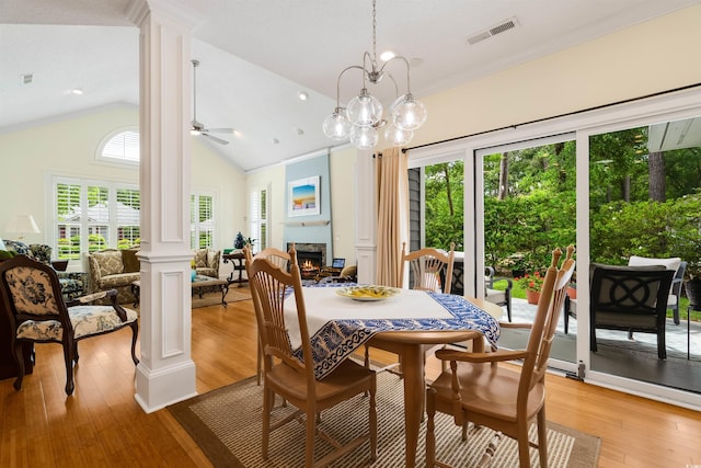 1325 Clipper Dr, North Myrtle Beach, SC 29582 - dining space featuring ornate columns, a lit fireplace, a ceiling fan, light wood finished floors, and high vaulted ceiling
