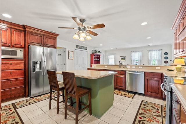 1609 Bridgebrook Ln, Conway, SC 29527 - kitchen with appliances with stainless steel finishes, a ceiling fan, a peninsula, light tile patterned floors, and light countertops