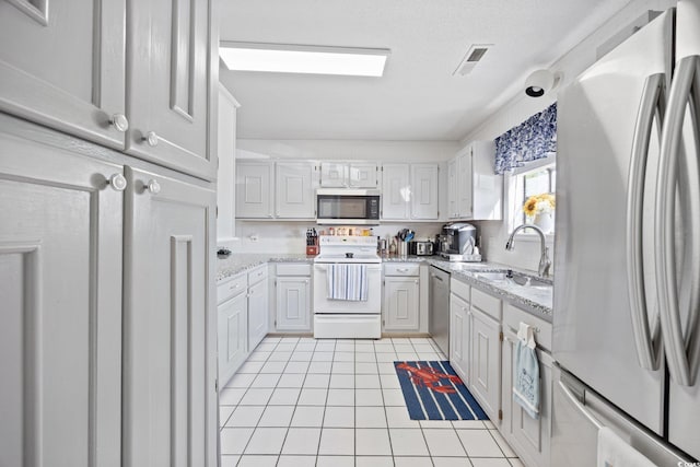 775 Plantation Dr Unit 28, Little River, SC 29566 - kitchen featuring stainless steel appliances, light tile patterned flooring, light stone countertops, and white cabinets