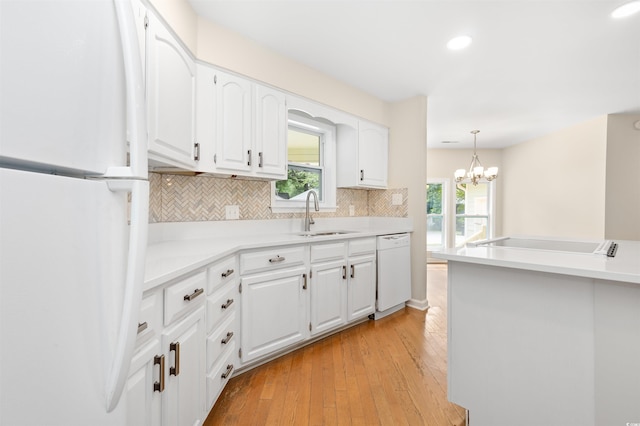 814 Night Heron Ln, Myrtle Beach, SC 29572 - kitchen with white appliances, a sink, decorative backsplash, white cabinets, and light wood-style flooring