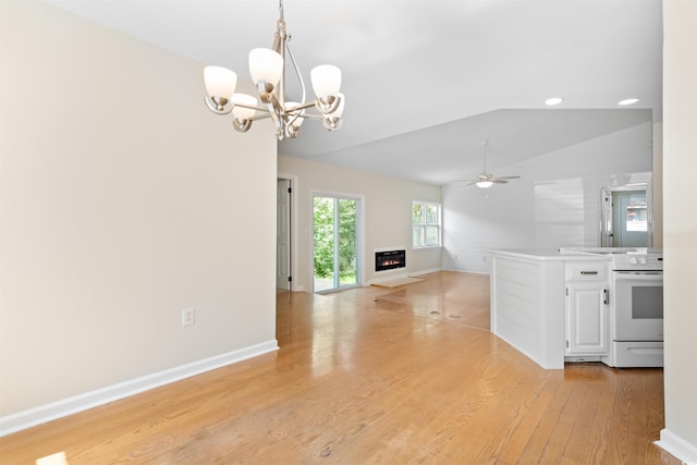 814 Night Heron Ln, Myrtle Beach, SC 29572 - spare room featuring vaulted ceiling, light wood-style floors, a chandelier, a glass covered fireplace, and ceiling fan