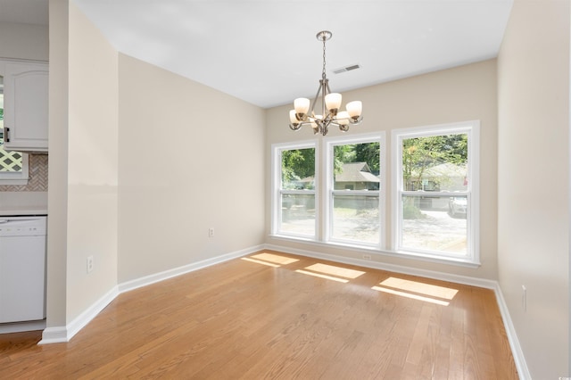 814 Night Heron Ln, Myrtle Beach, SC 29572 - unfurnished dining area with a chandelier, light wood-type flooring, and baseboards