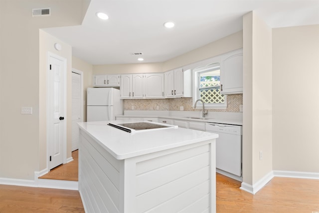 814 Night Heron Ln, Myrtle Beach, SC 29572 - kitchen featuring white appliances, a sink, decorative backsplash, a center island, and light wood-style floors