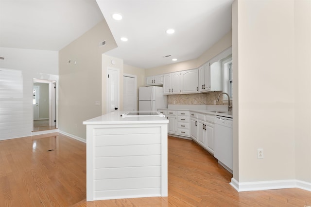 814 Night Heron Ln, Myrtle Beach, SC 29572 - kitchen with white appliances, a sink, light wood finished floors, tasteful backsplash, and light countertops