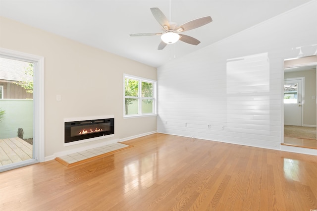 814 Night Heron Ln, Myrtle Beach, SC 29572 - unfurnished living room with vaulted ceiling, wood finished floors, ceiling fan, a glass covered fireplace, and baseboards