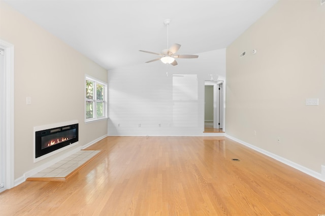 814 Night Heron Ln, Myrtle Beach, SC 29572 - unfurnished living room featuring light wood finished floors, vaulted ceiling, a fireplace, a ceiling fan, and baseboards