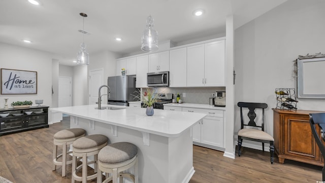 4053 Taranto Loop Unit C, Myrtle Beach, SC 29579 - kitchen with appliances with stainless steel finishes, a center island with sink, dark wood finished floors, backsplash, and white cabinetry