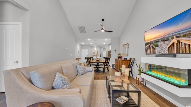 4053 Taranto Loop Unit C, Myrtle Beach, SC 29579 - living room with wood finished floors, high vaulted ceiling, a glass covered fireplace, a ceiling fan, and recessed lighting