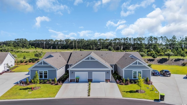 4053 Taranto Loop Unit C, Myrtle Beach, SC 29579 - view of front of house with a front yard, driveway, an attached garage, and view of wooded area