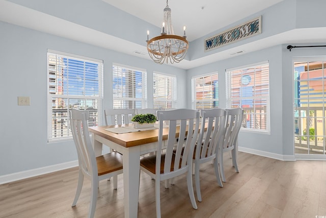 3401 N Ocean Blvd Unit 110, North Myrtle Beach, SC 29582 - dining area featuring a chandelier, light wood finished floors, baseboards, and plenty of natural light