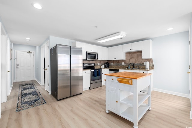 3401 N Ocean Blvd Unit 110, North Myrtle Beach, SC 29582 - kitchen featuring stainless steel appliances, butcher block countertops, a sink, open shelves, and baseboards