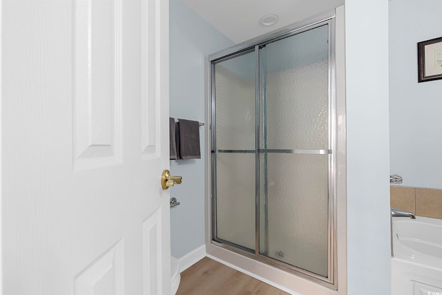 3401 N Ocean Blvd Unit 110, North Myrtle Beach, SC 29582 - bathroom featuring a stall shower, a garden tub, and wood finished floors