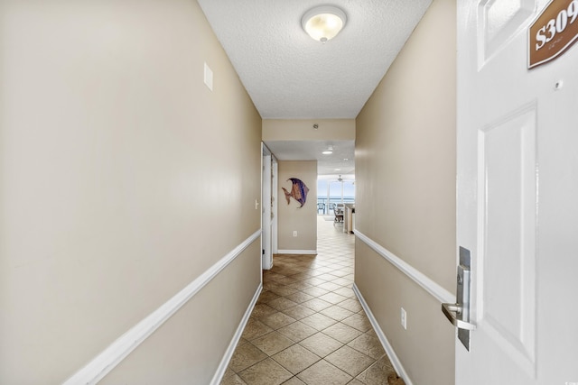 1625 S Ocean Blvd Unit 309, North Myrtle Beach, SC 29582 - hallway featuring a textured ceiling, baseboards, and light tile patterned floors