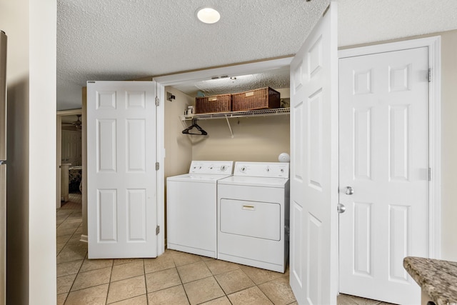 1625 S Ocean Blvd Unit 309, North Myrtle Beach, SC 29582 - laundry room with washing machine and dryer, light tile patterned flooring, and a textured ceiling
