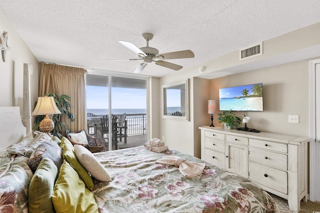 1625 S Ocean Blvd Unit 309, North Myrtle Beach, SC 29582 - bedroom featuring access to outside, a textured ceiling, ceiling fan, and a wall of windows