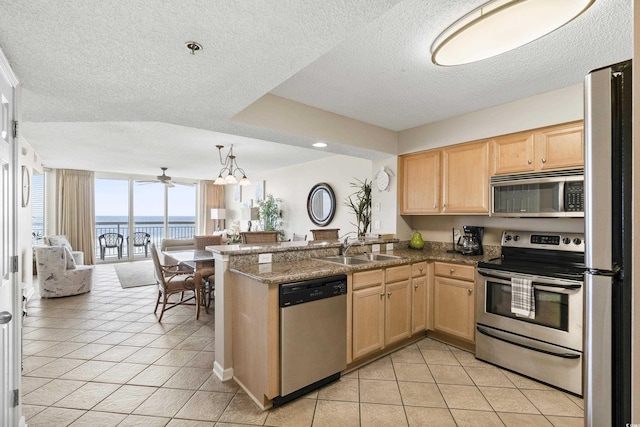 1625 S Ocean Blvd Unit 309, North Myrtle Beach, SC 29582 - kitchen featuring stainless steel appliances, open floor plan, a sink, a textured ceiling, and a water view