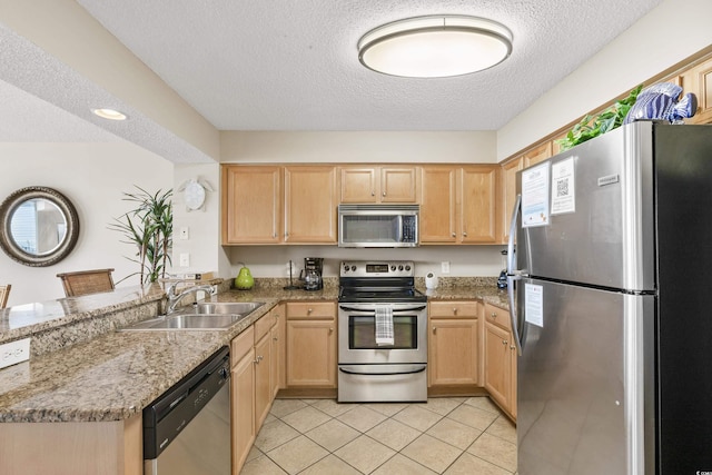 1625 S Ocean Blvd Unit 309, North Myrtle Beach, SC 29582 - kitchen featuring appliances with stainless steel finishes, a sink, light brown cabinetry, a peninsula, and a textured ceiling
