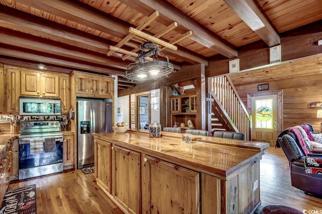 181 Halfway Rd, Nichols, SC 29581 - kitchen with appliances with stainless steel finishes, wooden walls, light wood-style flooring, a center island, and wood ceiling with exposed beams