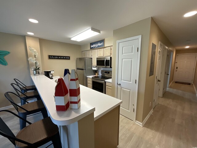 1900 Duffy St Unit L-5, North Myrtle Beach, SC 29582 - kitchen with appliances with stainless steel finishes, a kitchen bar, baseboards, light wood-type flooring, and recessed lighting