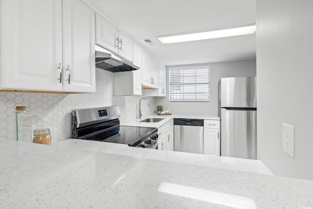 6703 Jefferson Pl Unit B7, Myrtle Beach, SC 29572 - kitchen with stainless steel appliances, under cabinet range hood, white cabinets, backsplash, and light stone counters
