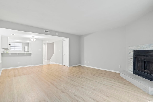 6703 Jefferson Pl Unit B7, Myrtle Beach, SC 29572 - unfurnished living room featuring light wood-type flooring and a fireplace with raised hearth