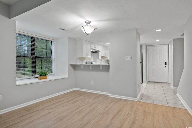6703 Jefferson Pl Unit B7, Myrtle Beach, SC 29572 - kitchen with light wood finished floors, white cabinetry, recessed lighting, and under cabinet range hood