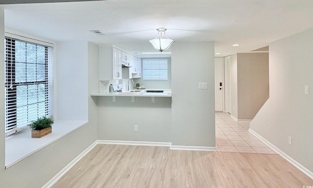 6703 Jefferson Pl Unit B7, Myrtle Beach, SC 29572 - kitchen with light wood-style flooring, light countertops, white cabinets, a peninsula, and recessed lighting
