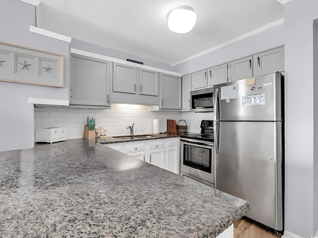 1310 N Waccamaw Dr Unit 208, Garden City Beach, SC 29576 - kitchen featuring stainless steel appliances, a sink, dark stone countertops, ornamental molding, and backsplash