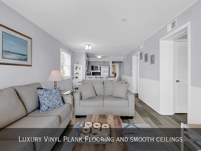 1310 N Waccamaw Dr Unit 208, Garden City Beach, SC 29576 - living room with wood finished floors, a wainscoted wall, and ornamental molding