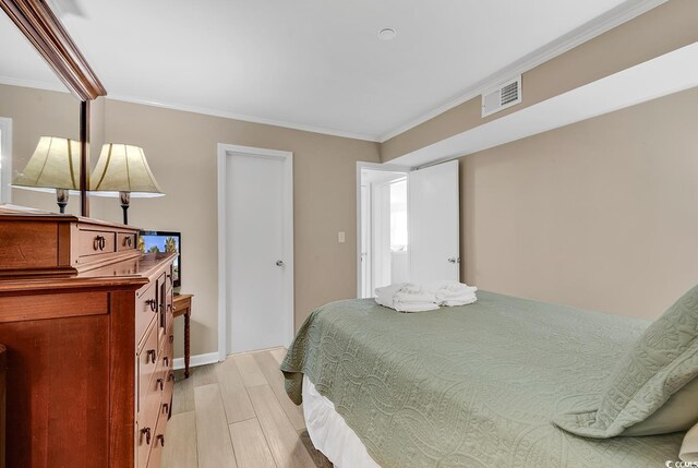 1310 N Waccamaw Dr Unit 208, Garden City Beach, SC 29576 - bedroom featuring ornamental molding, light wood finished floors, and baseboards