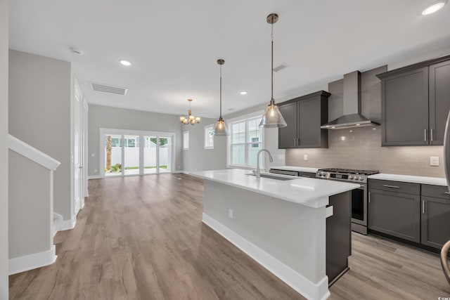1545 Coastal Cove Ln, Calabash, NC 28467 - kitchen with wall chimney exhaust hood, a sink, stainless steel gas range, a chandelier, and light wood-type flooring