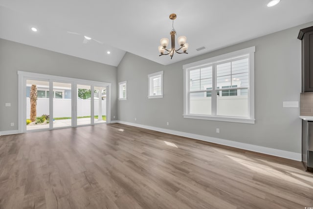 1545 Coastal Cove Ln, Calabash, NC 28467 - unfurnished living room featuring a chandelier, vaulted ceiling, baseboards, light wood-type flooring, and recessed lighting