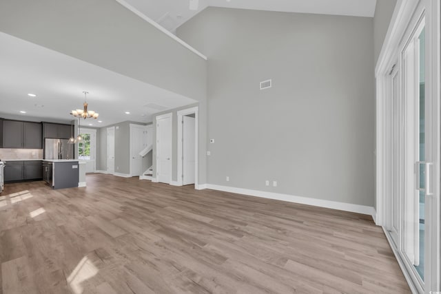 1545 Coastal Cove Ln, Calabash, NC 28467 - unfurnished living room with a chandelier, baseboards, stairway, recessed lighting, and light wood-type flooring