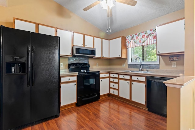 752 Tall Oaks Ct, Myrtle Beach, SC 29588 - kitchen with black appliances, a sink, vaulted ceiling, dark wood-style flooring, and white cabinetry