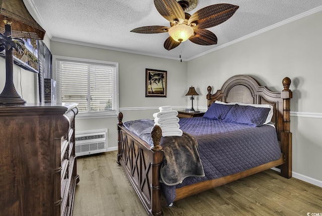 9660 Shore Dr Unit 208, Myrtle Beach, SC 29572 - bedroom featuring a textured ceiling, a wall mounted air conditioner, wood finished floors, crown molding, and baseboards