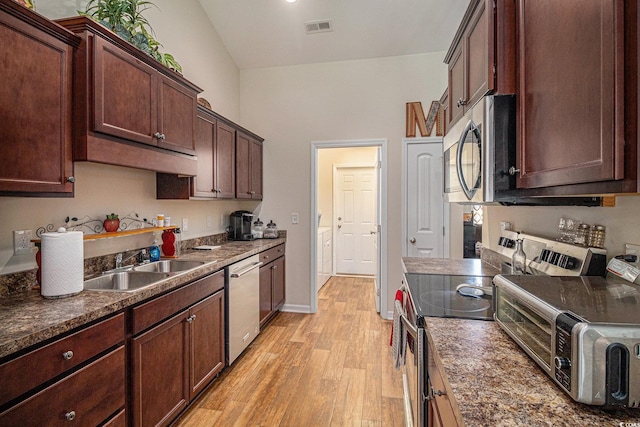 95 Timber Run Dr, Georgetown, SC 29440 - kitchen featuring appliances with stainless steel finishes, independent washer and dryer, light wood-style floors, and dark countertops
