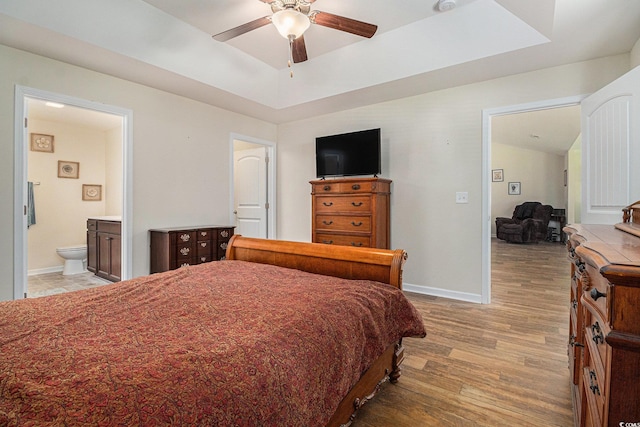 95 Timber Run Dr, Georgetown, SC 29440 - bedroom featuring light wood-style floors, a tray ceiling, connected bathroom, and ceiling fan