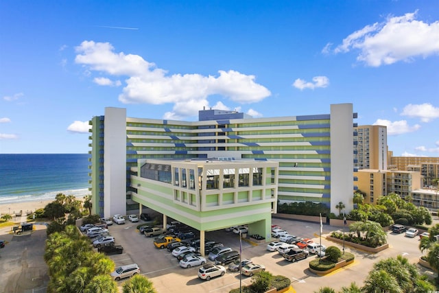 1105 S Ocean Blvd Unit 110, Myrtle Beach, SC 29577 - view of building exterior with view of water and beach and uncovered parking