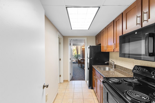 1105 S Ocean Blvd Unit 110, Myrtle Beach, SC 29577 - kitchen featuring black appliances, brown cabinetry, a sink, dark stone countertops, and light tile patterned floors