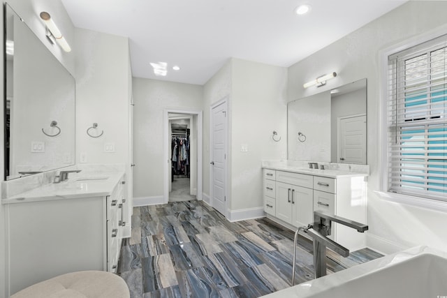 208 W Palms Dr, Myrtle Beach, SC 29579 - bathroom with two vanities, a tub, a spacious closet, baseboards, and recessed lighting