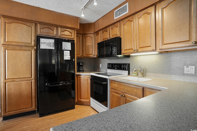 5905 S Kings Hwy Unit A518, Myrtle Beach, SC 29575 - kitchen with black appliances, a sink, light countertops, a textured ceiling, and track lighting
