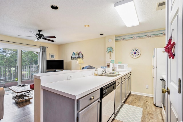 1900 Duffy St Unit H-8, North Myrtle Beach, SC 29582 - kitchen with white appliances, a sink, a peninsula, light wood-style floors, and a textured ceiling