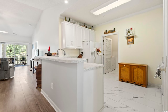 5852 Longwood Dr Unit 302, Murrells Inlet, SC 29576 - kitchen featuring white fridge with ice dispenser, white cabinets, vaulted ceiling, a peninsula, and open floor plan