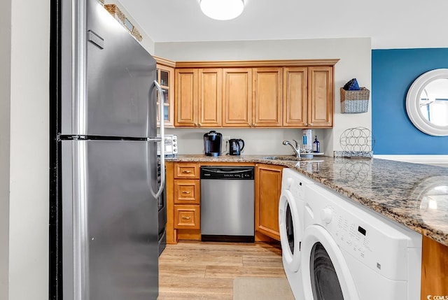 2500 N Ocean Blvd Unit 1102, Myrtle Beach, SC 29577 - kitchen featuring stainless steel appliances, light stone countertops, light wood-style flooring, washer and dryer, and glass insert cabinets