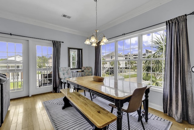 113-A Vista Dr, Garden City Beach, SC 29576 - dining area featuring a chandelier, light wood-style floors, crown molding, and healthy amount of natural light