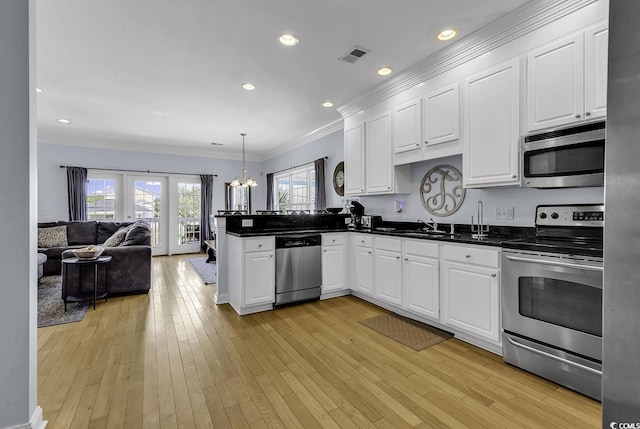113-A Vista Dr, Garden City Beach, SC 29576 - kitchen with appliances with stainless steel finishes, crown molding, a peninsula, dark countertops, and open floor plan