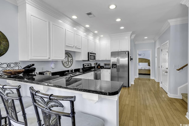 113-A Vista Dr, Garden City Beach, SC 29576 - kitchen with appliances with stainless steel finishes, a peninsula, a sink, white cabinetry, and recessed lighting